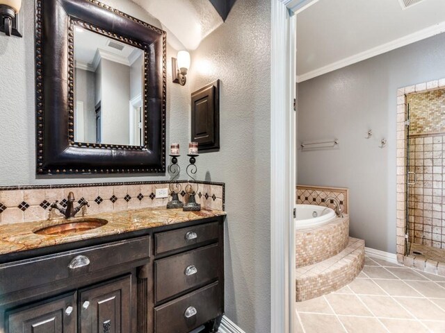 bathroom featuring plus walk in shower, vanity, tile patterned floors, and crown molding