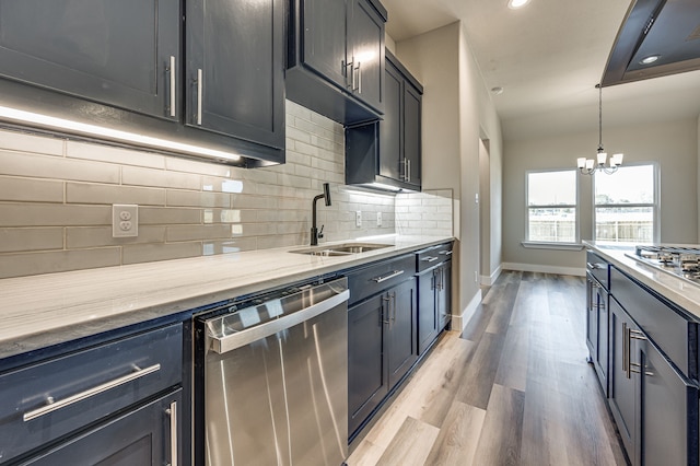 kitchen featuring stainless steel appliances, sink, a chandelier, light hardwood / wood-style floors, and hanging light fixtures