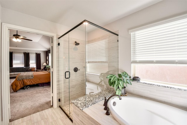 bathroom with plus walk in shower, vaulted ceiling, and ceiling fan