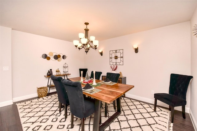 dining space with hardwood / wood-style flooring and a notable chandelier