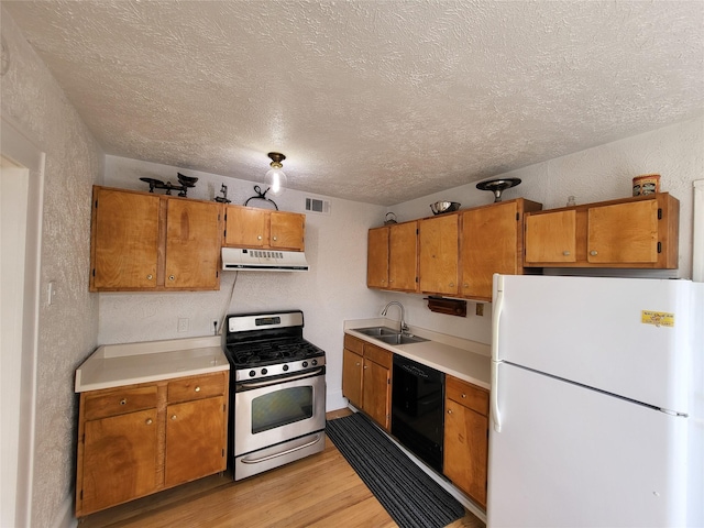 kitchen with sink, dishwasher, stainless steel gas range, range hood, and white refrigerator