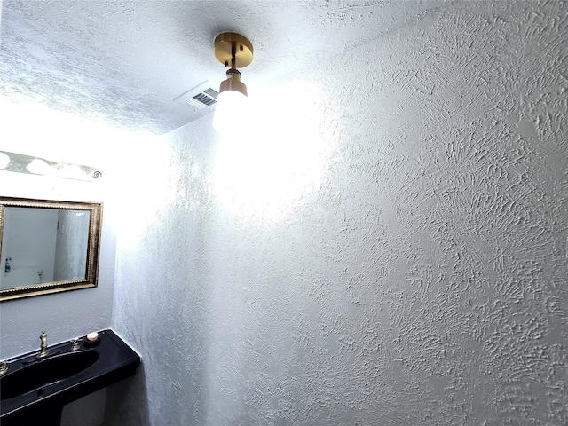 bathroom featuring sink and a textured ceiling