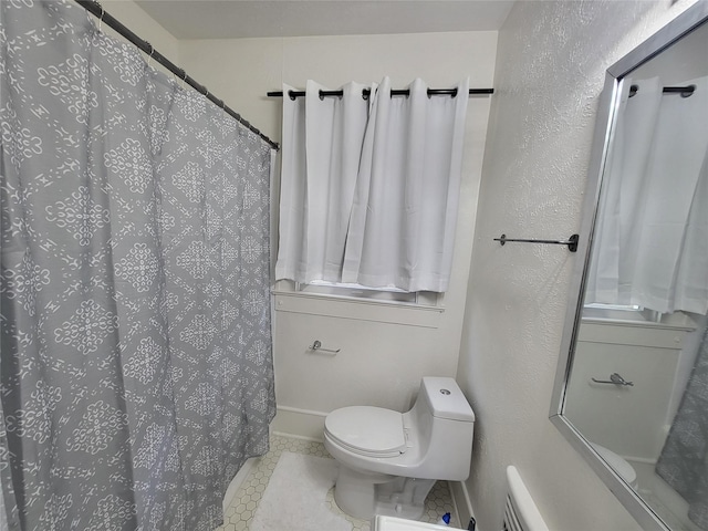 bathroom featuring tile patterned floors, walk in shower, and toilet