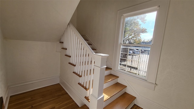 stairs featuring hardwood / wood-style floors and lofted ceiling