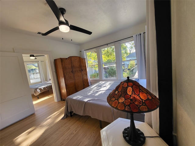 bedroom with light hardwood / wood-style flooring and ceiling fan