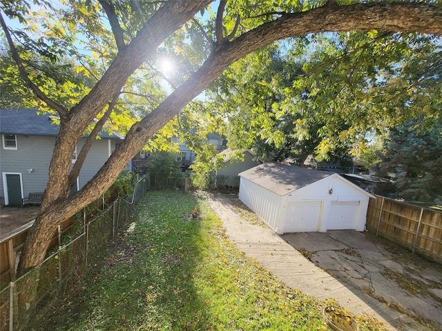 view of yard featuring a garage and an outbuilding