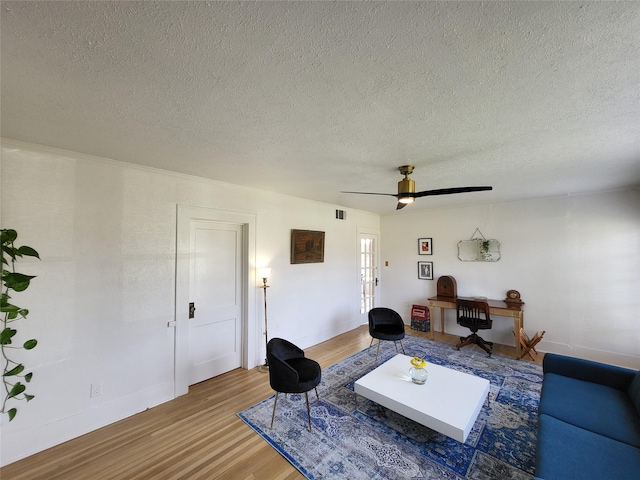 living room with french doors, a textured ceiling, hardwood / wood-style flooring, and ceiling fan