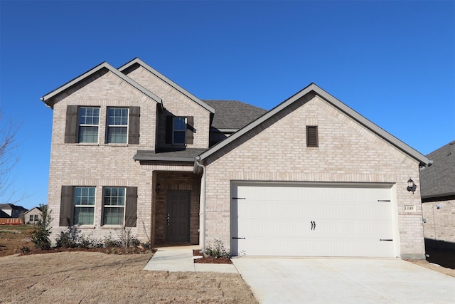 view of front of property featuring driveway, a shingled roof, a garage, and brick siding