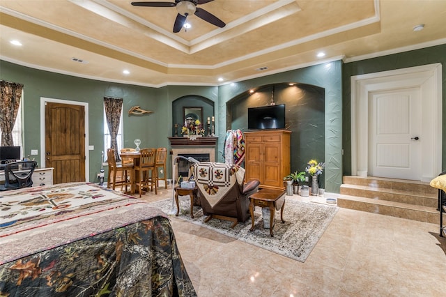 bedroom featuring visible vents, a raised ceiling, a tiled fireplace, ornamental molding, and recessed lighting