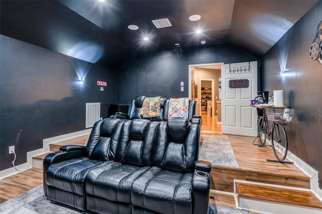 cinema featuring baseboards, visible vents, vaulted ceiling, and wood finished floors