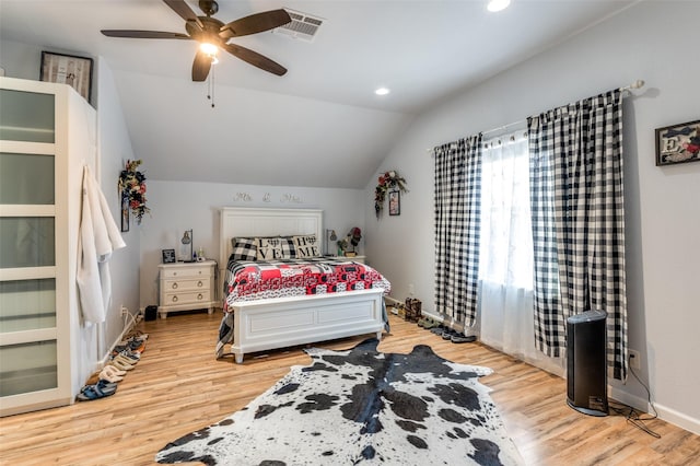 bedroom with visible vents, baseboards, ceiling fan, light wood-style flooring, and vaulted ceiling