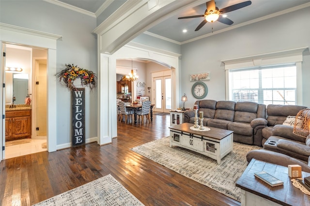 living room featuring hardwood / wood-style flooring, ceiling fan with notable chandelier, baseboards, french doors, and crown molding