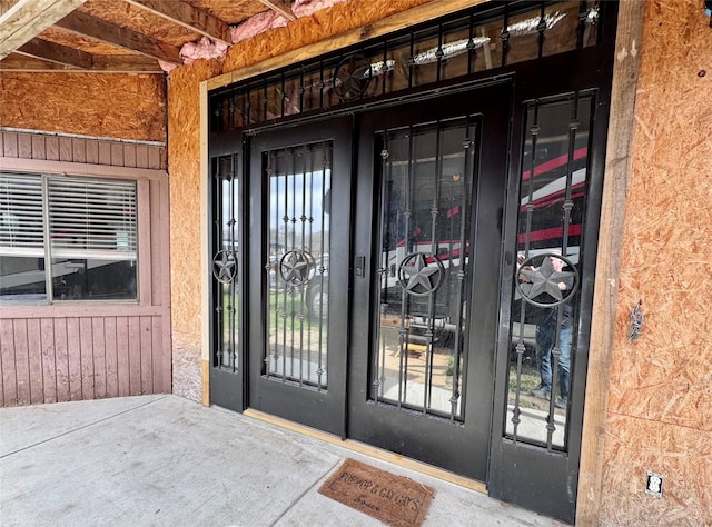 property entrance featuring stucco siding and french doors