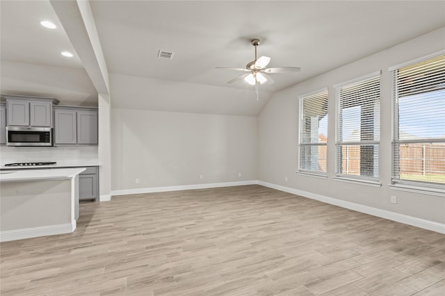 unfurnished living room featuring light hardwood / wood-style floors, ceiling fan, and lofted ceiling