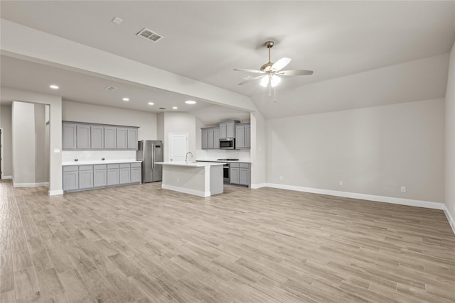 unfurnished living room featuring ceiling fan, light hardwood / wood-style floors, and lofted ceiling