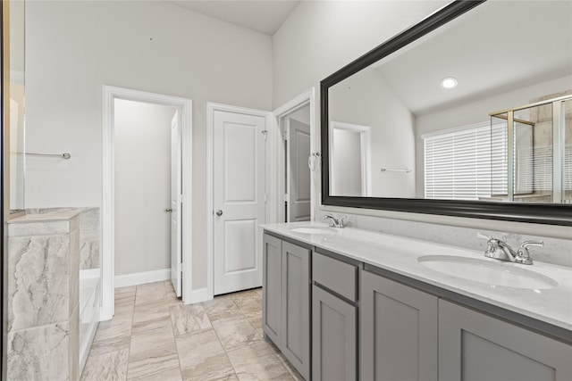 bathroom featuring vanity, vaulted ceiling, and a bathtub