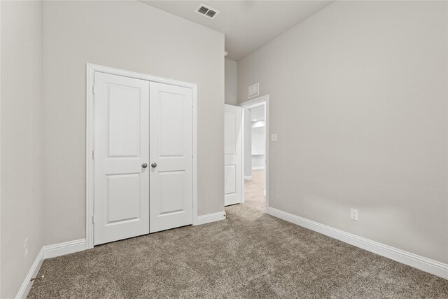 unfurnished bedroom featuring carpet flooring and a closet