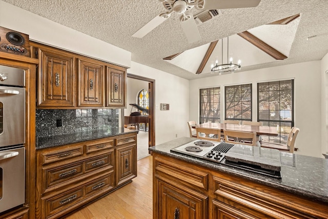 kitchen featuring hanging light fixtures, a textured ceiling, and light wood-type flooring