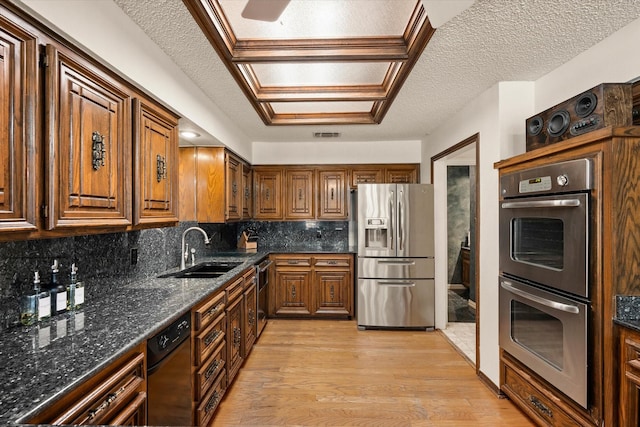 kitchen with tasteful backsplash, light hardwood / wood-style flooring, stainless steel appliances, and a textured ceiling