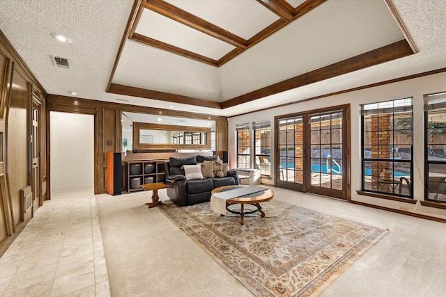 living room with a tray ceiling, light carpet, crown molding, and a textured ceiling