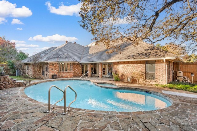 view of pool featuring a patio area and an in ground hot tub