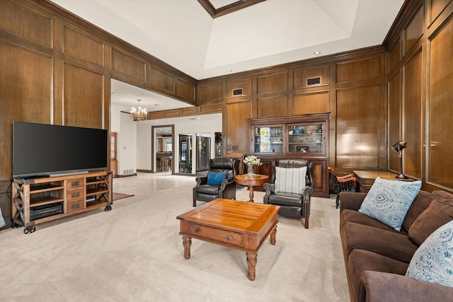 living room featuring ornamental molding, a towering ceiling, light colored carpet, and an inviting chandelier