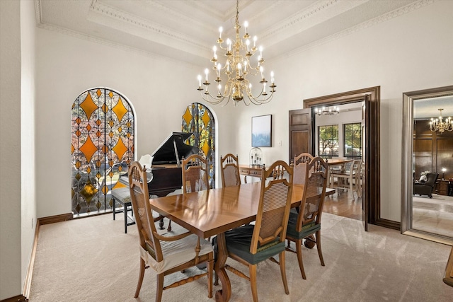 carpeted dining room featuring a towering ceiling, crown molding, a tray ceiling, and a chandelier