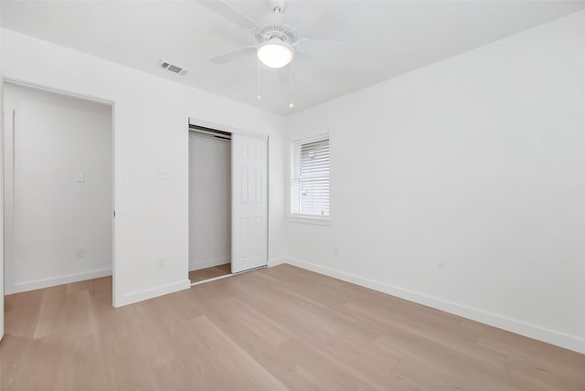 unfurnished bedroom with ceiling fan, light wood-type flooring, and a closet