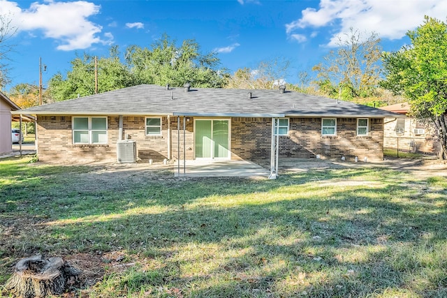 rear view of property with a lawn, central AC, and a patio area