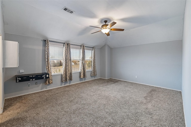 spare room featuring carpet floors, vaulted ceiling, and ceiling fan