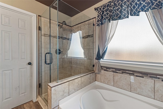 bathroom featuring wood-type flooring and independent shower and bath