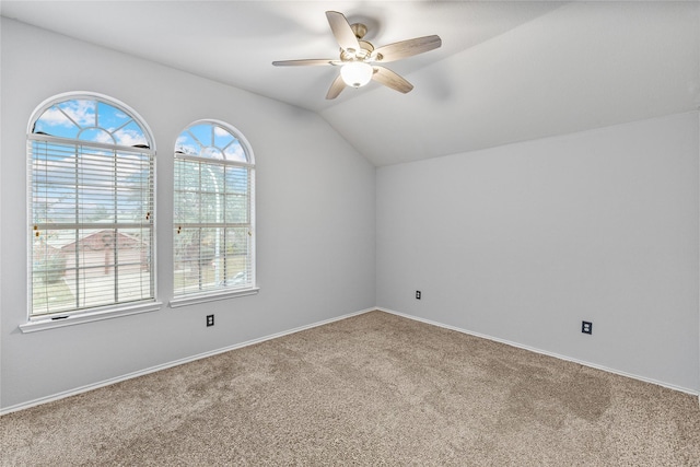 empty room with lofted ceiling, carpet, and ceiling fan