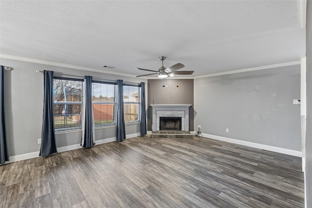 unfurnished living room featuring dark hardwood / wood-style floors, ornamental molding, a fireplace, and a textured ceiling