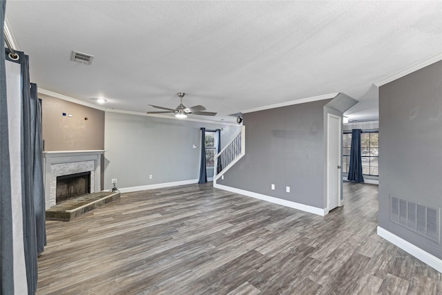 unfurnished living room featuring hardwood / wood-style flooring, a premium fireplace, a textured ceiling, and crown molding