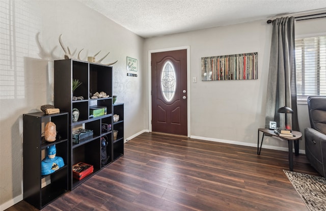 entryway with a textured ceiling, dark hardwood / wood-style flooring, and a healthy amount of sunlight