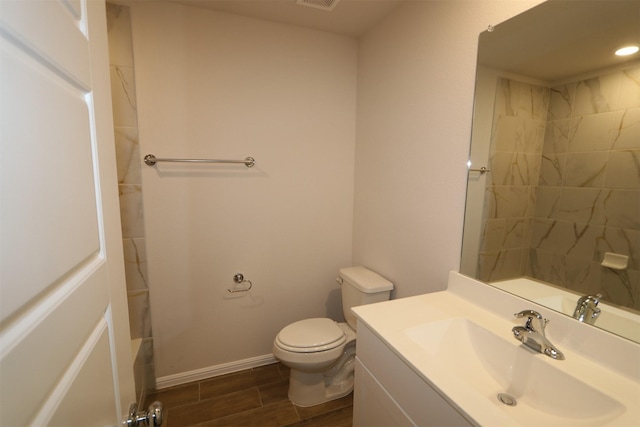 full bathroom with toilet, wood tiled floor, baseboards, and vanity