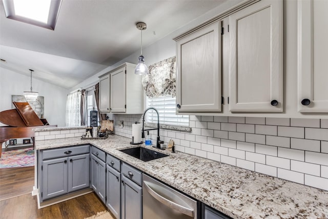 kitchen featuring dishwasher, sink, decorative backsplash, gray cabinets, and decorative light fixtures