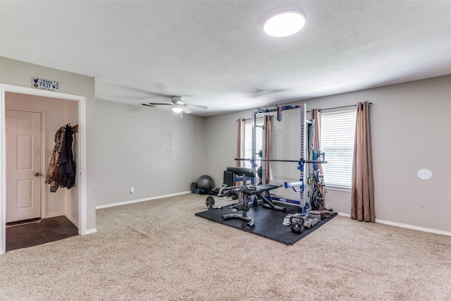 workout room featuring ceiling fan, a textured ceiling, and dark colored carpet