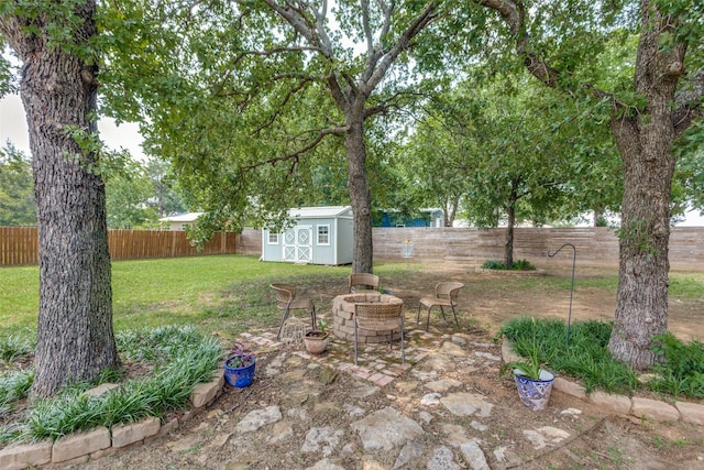 view of yard with a fire pit and a storage unit