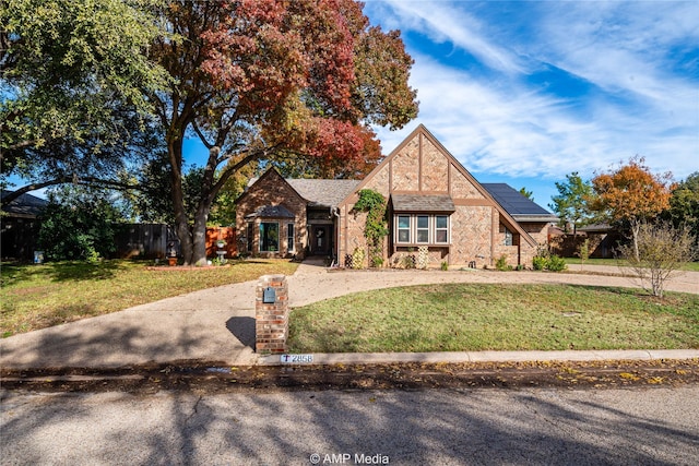 view of front of house with a front lawn and solar panels