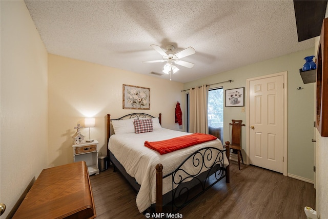 bedroom featuring ceiling fan, dark hardwood / wood-style floors, and a textured ceiling