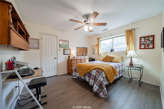 bedroom featuring ceiling fan, dark wood-type flooring, and a textured ceiling