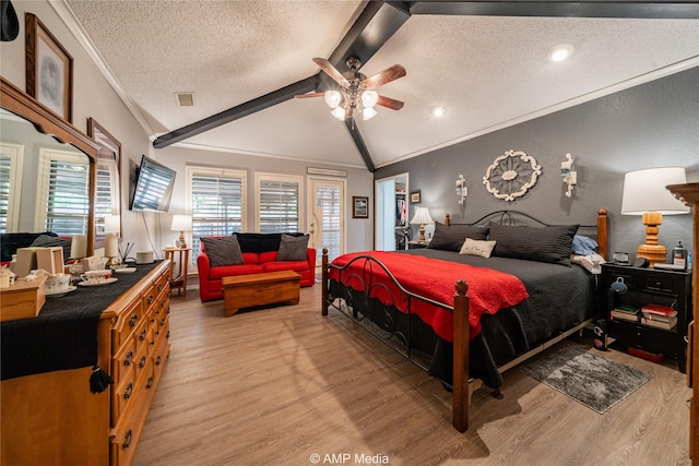 bedroom with lofted ceiling with beams, ornamental molding, hardwood / wood-style floors, and a textured ceiling