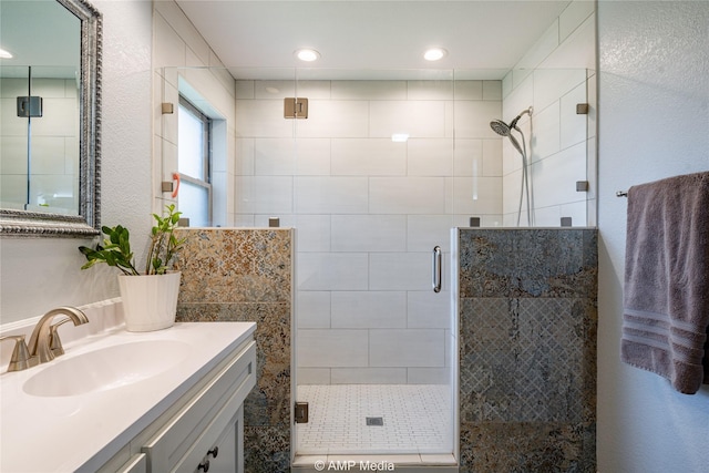 bathroom featuring vanity and a shower with door