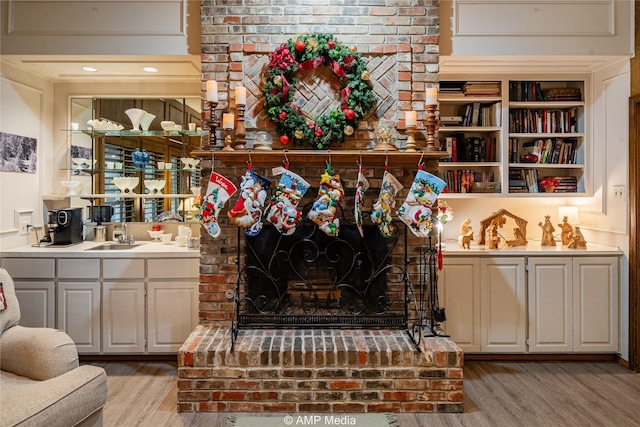 details featuring wood-type flooring, a brick fireplace, and sink