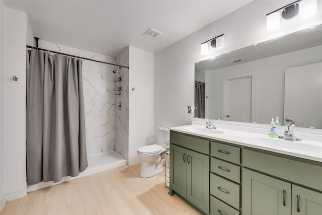 bathroom with vanity, wood-type flooring, toilet, and walk in shower