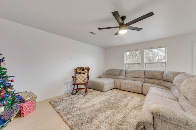 living room featuring wood-type flooring and ceiling fan