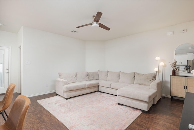 living room featuring ceiling fan and dark hardwood / wood-style flooring