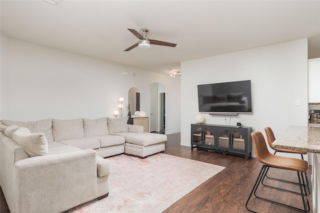 living room featuring ceiling fan and dark hardwood / wood-style floors