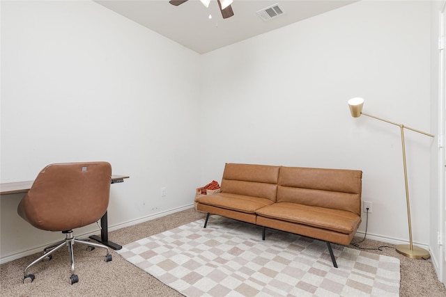 carpeted office space featuring ceiling fan